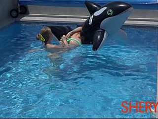 Two girls are having fun in the pool.